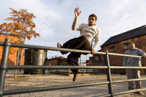 Traceur balancing above metal rails during Sheffield parkour training