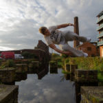 Traceur jumping between obstacles during outdoor parkour training