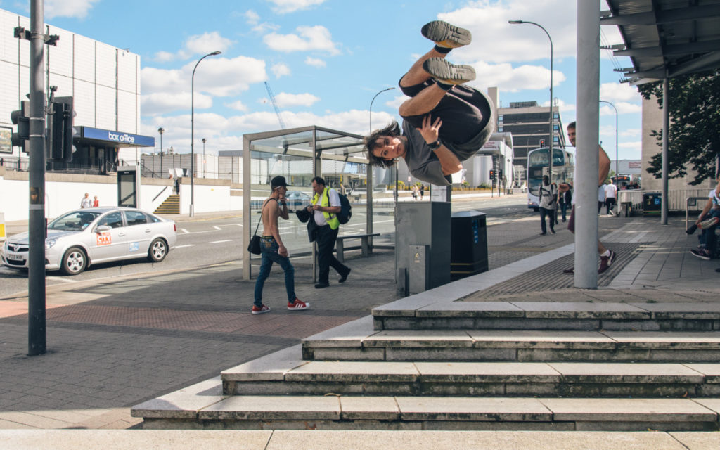 Traceur performing a jump above city-centre steps