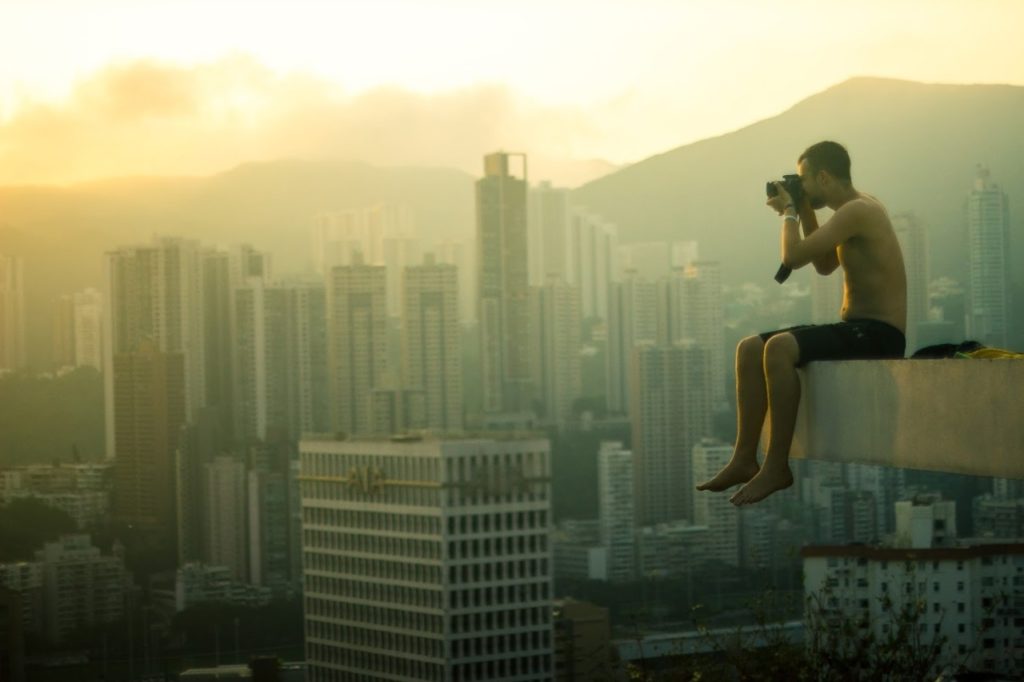 Traceur sitting above a city skyline in warm evening light